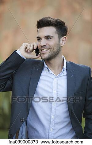 Stock Image - Businessman using cell phone outdoors. Fotosearch