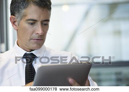 Stock Photo - Businessman using digital tablet. Fotosearch
