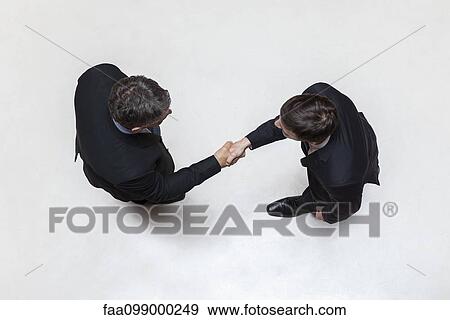 Businessmen shaking hands, overhead view View Large Photo Image Stock Photo - Businessmen shaking hands, overhead view. Fotosearch