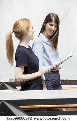 Colleagues discussing work together View Large Photo Image Stock Image - Colleagues discussing work together. Fotosearch