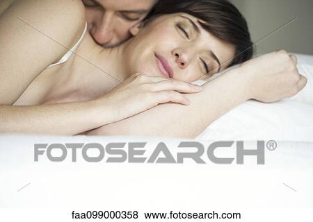 Couple cuddling in bed View Large Photo Image Stock Photo - Couple cuddling in bed. Fotosearch