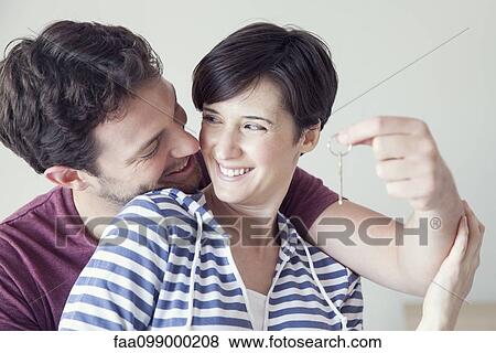 Stock Photo - Couple holding up new house key. Fotosearch