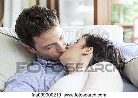 Stock Photo - Couple kissing on sofa. Fotosearch