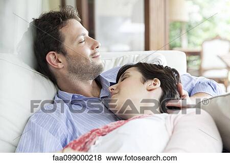 Couple napping together on sofa View Large Photo Image Stock Photo - Couple napping together on sofa. Fotosearch
