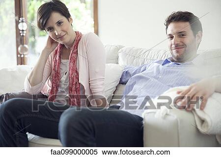 Stock Photography - Couple relaxing on sofa. Fotosearch