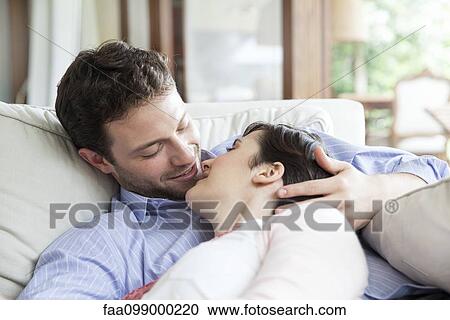 Couple relaxing together on sofa, preparing to kiss View Large Photo Image Stock Image - Couple relaxing together on sofa, preparing to kiss. Fotosearch