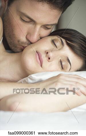 Couple together in bed, husband kissing wife's cheek View Large Photo Image Stock Image - Couple together in bed, husband kissing wife's cheek. Fotosearch