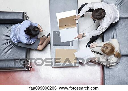 Executives in business meeting, overhead view View Large Photo Image Stock Image - Executives in business meeting, overhead view. Fotosearch