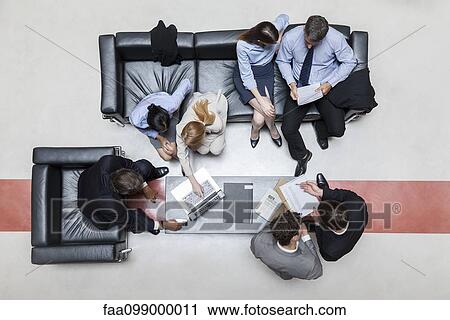 Stock Image - Executives in meeting, overhead view. Fotosearch
