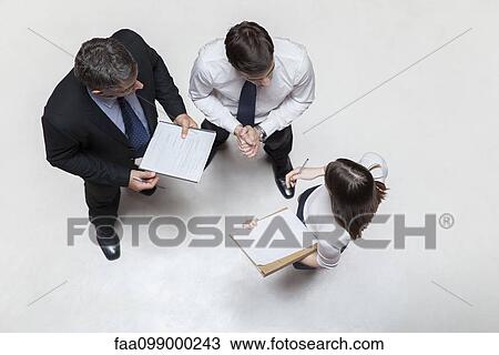 Stock Image - Executives in meeting, overhead view. Fotosearch