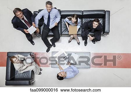 Executives in meeting, smiling at camera, overhead view View Large Photo Image Stock Photograph - Executives in meeting, smiling at camera, overhead view. Fotosearch