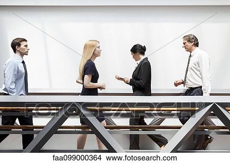 Picture - Executives walking in corridor. Fotosearch