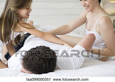 Family playing on bed View Large Photo Image Stock Photo - Family playing on bed. Fotosearch
