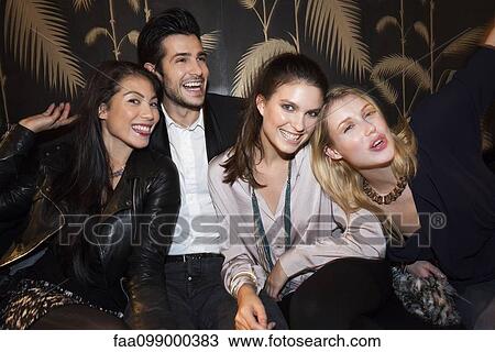 Friends hanging out at night club View Large Photo Image Stock Image - Friends hanging out at night club. Fotosearch