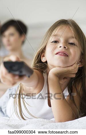 Picture - Little girl holding remote control. Fotosearch