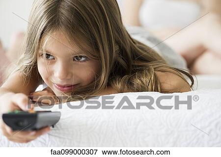 Stock Photo - Little girl holding remote control. Fotosearch