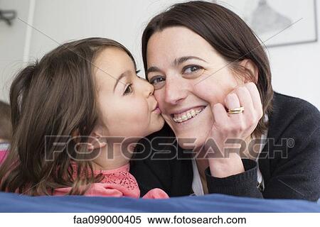 Stock Photography - Little girl kissing mother's cheek. Fotosearch