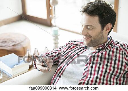 Man using smartphone at home View Large Photo Image Picture - Man using smartphone at home. Fotosearch
