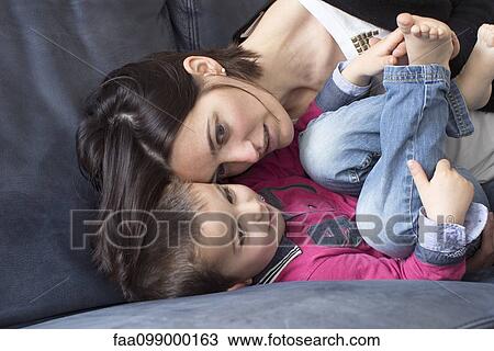 Mother and young son relaxing together on sofa View Large Photo Image Stock Image - Mother and young son relaxing together on sofa. Fotosearch