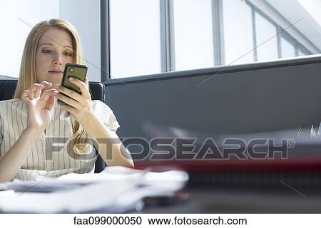Office worker text messaging at desk View Large Photo Image Stock Image - Office worker text messaging at desk. Fotosearch
