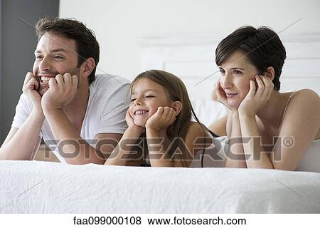 Parents and daughter lying on bed together, portrait View Large Photo Image Stock Photo - Parents and daughter lying on bed together, portrait. Fotosearch