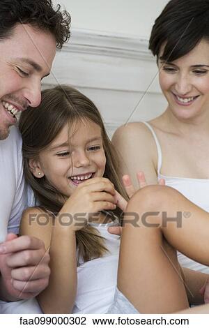 Stock Image - Parents and daughter playing. Fotosearch