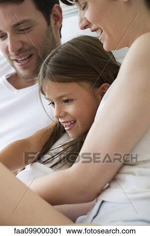 Parents and daughter reading together View Large Photo Image Stock Image - Parents and daughter reading together. Fotosearch
