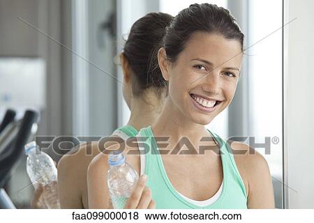 Stock Photo - Taking break at gym to hydrate. Fotosearch