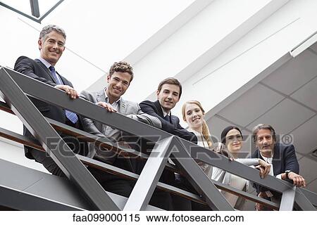 Stock Photography - Team of executives standing together on balcony. Fotosearch