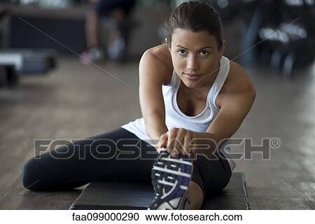 Woman at gym warming up with leg stretches View Large Photo Image Stock Image - Woman at gym warming up with leg stretches. Fotosearch