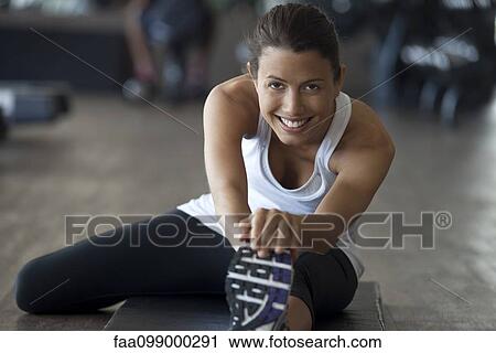 Woman at gym warming up with leg stretches View Large Photo Image Stock Image - Woman at gym warming up with leg stretches. Fotosearch