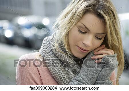 Picture - Woman dressed warmly in knit gloves and scarf. Fotosearch