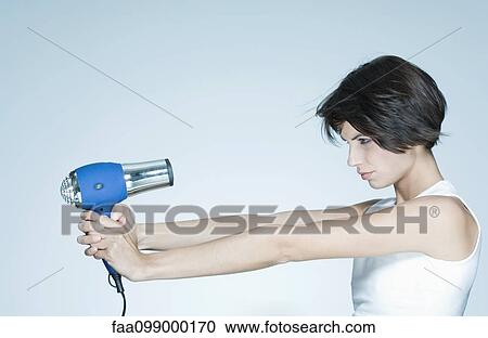 Woman holding out hair dryer, profile View Large Photo Image Stock Image - Woman holding out hair dryer, profile. Fotosearch