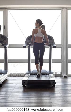 Woman jogging on treadmill at gym View Large Photo Image Stock Photo - Woman jogging on treadmill at gym. Fotosearch