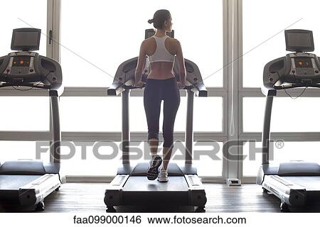 Woman jogging on treadmill at gym View Large Photo Image Stock Photograph - Woman jogging on treadmill at gym. Fotosearch