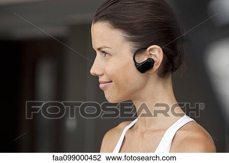 Woman listening to music with earphones, profile View Large Photo Image Stock Image - Woman listening to music with earphones, profile. Fotosearch