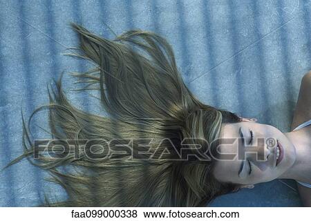 Woman lying in shade with her hair spread out on the ground View Large Photo Image Stock Photo - Woman lying in shade with her hair spread out on the ground. Fotosearch