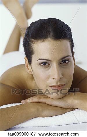 Woman lying on stomach with head resting on arms, portrait View Large Photo Image Stock Photo - Woman lying on stomach with head resting on arms, portrait. Fotosearch