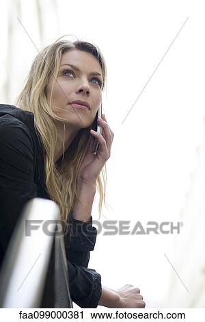 Woman outdoors using cell phone View Large Photo Image Stock Image - Woman outdoors using cell phone. Fotosearch