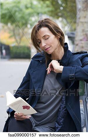 Stock Photo - Woman reading book outdoors. Fotosearch
