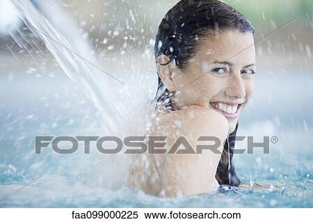 Woman relaxing under fountain in swimming pool View Large Photo Image Stock Photography - Woman relaxing under fountain in swimming pool. Fotosearch