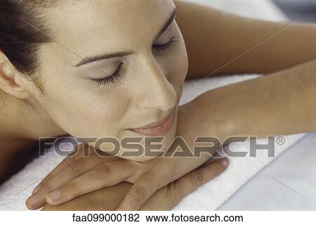 Stock Image - Woman resting chin on hands, eyes closed. Fotosearch