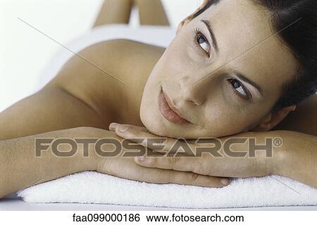 Woman resting head on arms, looking up and smiling View Large Photo Image Stock Photograph - Woman resting head on arms, looking up and smiling. Fotosearch