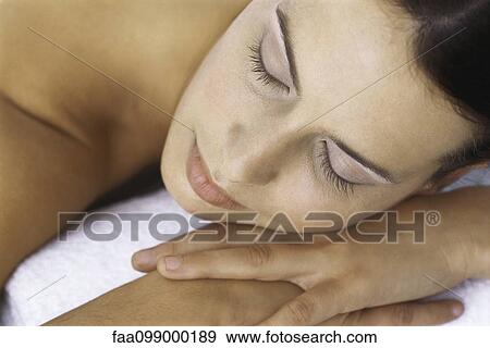 Stock Photo - Woman resting head on hands, eyes closed. Fotosearch