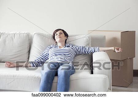 Woman resting on sofa while moving house View Large Photo Image Stock Image - Woman resting on sofa while moving house. Fotosearch