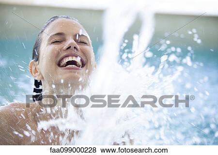 Woman splashing in pool with eyes closed View Large Photo Image Stock Photo - Woman splashing in pool with eyes closed. Fotosearch