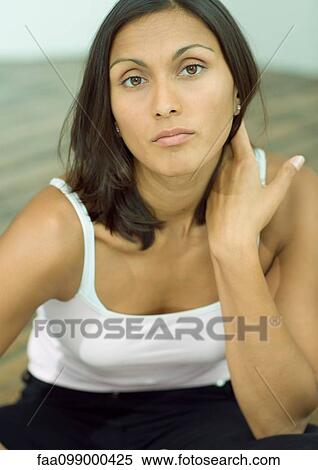 Stock Photography - Woman with hand on neck, portrait. Fotosearch