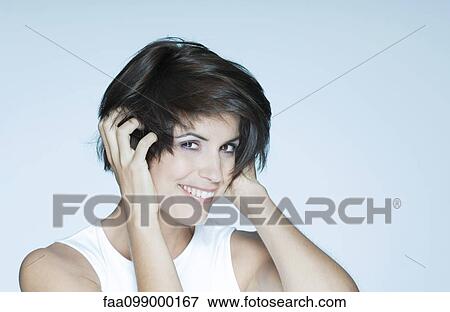 Woman with hands in hair, smiling, portrait View Large Photo Image Stock Photo - Woman with hands in hair, smiling, portrait. Fotosearch