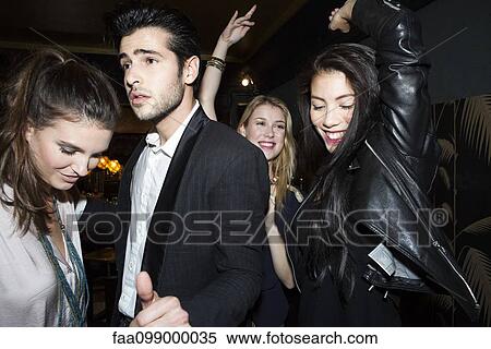 Stock Photography - Young adults dancing at night club. Fotosearch