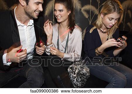 Stock Photograph - Young adults socializing at night club. Fotosearch
